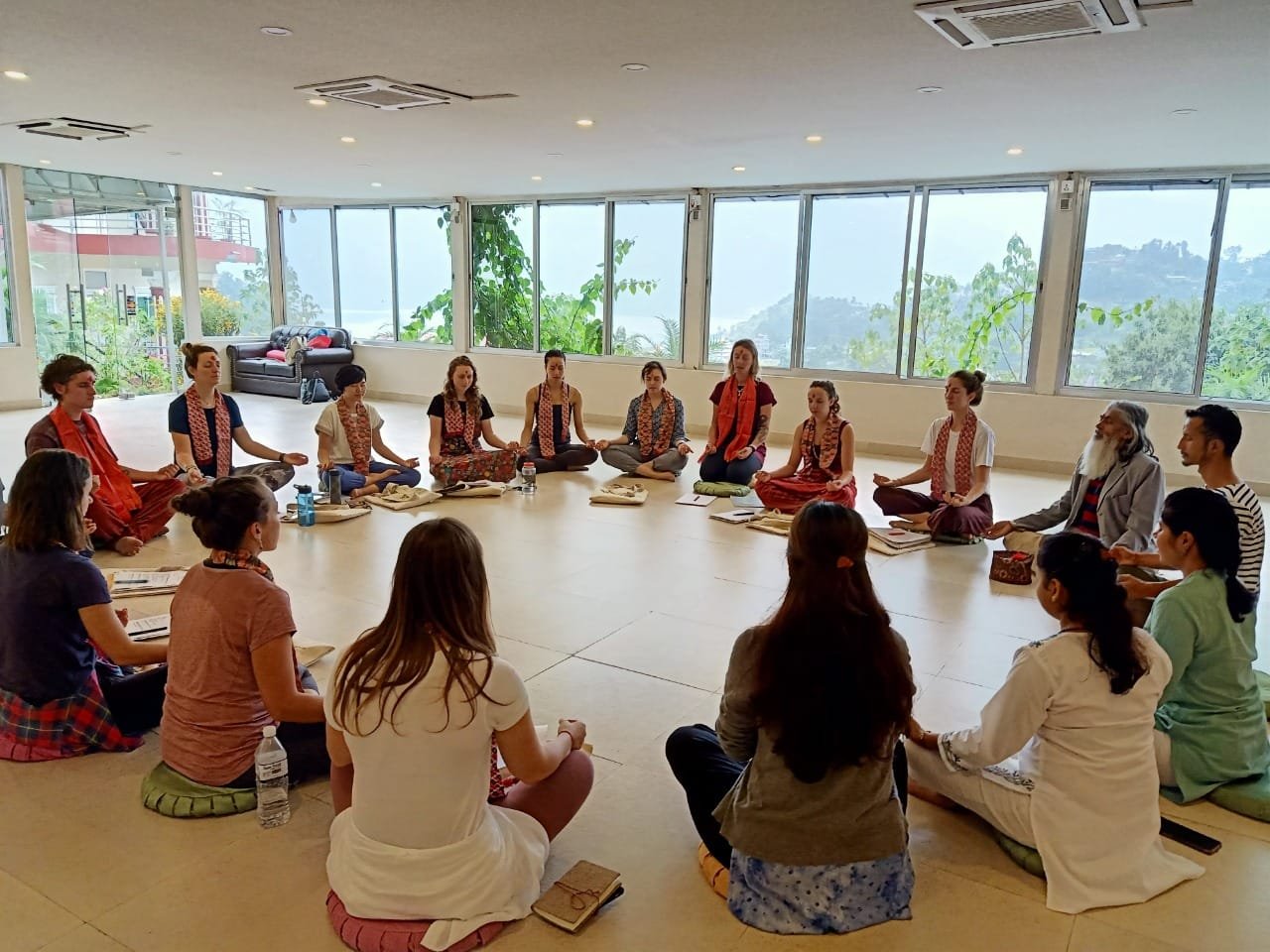 Group seated in a circle in a bright yoga hall